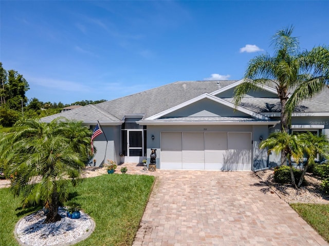 717 Manchester Woods Dr Unit 717, Sun City Center, FL 33573 - ranch-style home with an attached garage, stucco siding, decorative driveway, and a front yard