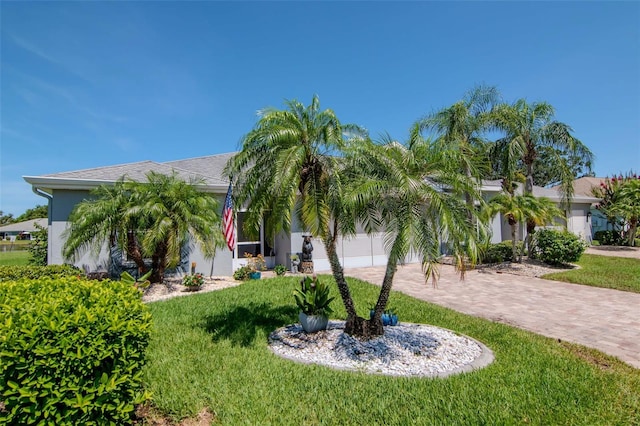 717 Manchester Woods Dr Unit 717, Sun City Center, FL 33573 - view of front facade with decorative driveway, a garage, a front lawn, and stucco siding