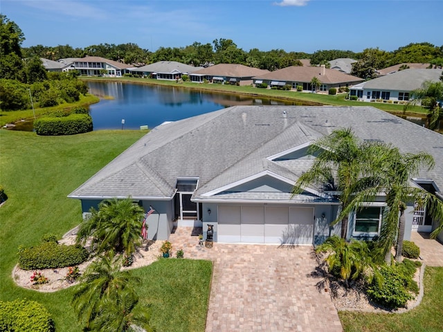 717 Manchester Woods Dr Unit 717, Sun City Center, FL 33573 - ranch-style home with a garage, decorative driveway, roof with shingles, and a water view