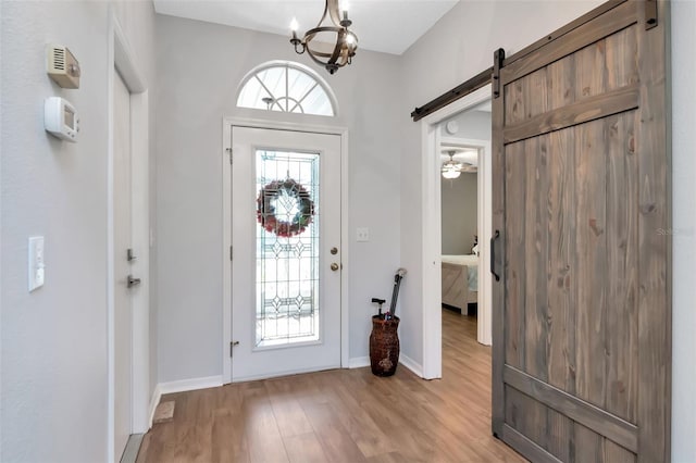 717 Manchester Woods Dr Unit 717, Sun City Center, FL 33573 - entryway featuring a barn door, light wood-style floors, and a chandelier