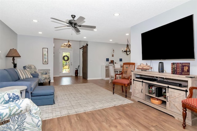 717 Manchester Woods Dr Unit 717, Sun City Center, FL 33573 - living room with a barn door, recessed lighting, light wood-style floors, a textured ceiling, and a ceiling fan