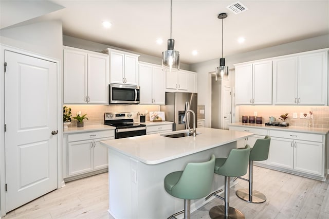 1128 Creek Valley Ct, Brandon, FL 33511 - kitchen featuring appliances with stainless steel finishes, tasteful backsplash, white cabinets, light countertops, and light wood-style flooring