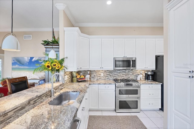 4743 Spinnaker Dr, Bradenton, FL 34208 - kitchen with appliances with stainless steel finishes, light tile patterned floors, backsplash, white cabinets, and crown molding