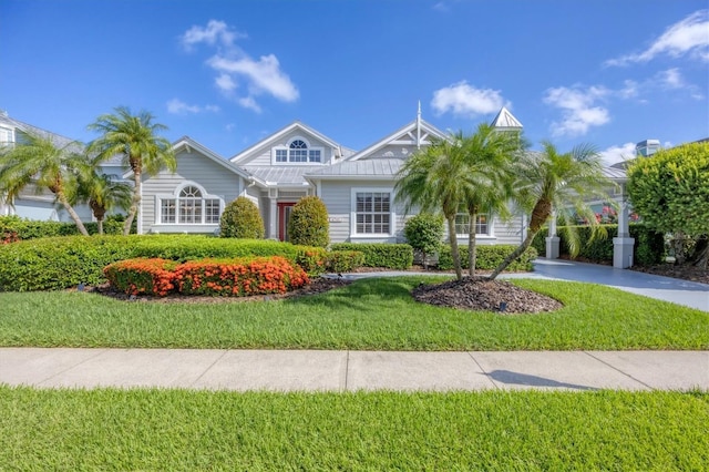 4743 Spinnaker Dr, Bradenton, FL 34208 - view of front of home with a front yard, a standing seam roof, and a metal roof