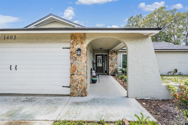 1403 Tallahassee Dr, Tarpon Springs, FL 34689 - property entrance with stucco siding, an attached garage, and stone siding