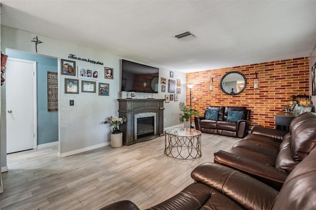1403 Tallahassee Dr, Tarpon Springs, FL 34689 - living room with a glass covered fireplace, light wood-type flooring, and brick wall