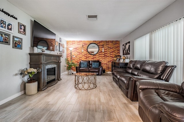1403 Tallahassee Dr, Tarpon Springs, FL 34689 - living room featuring light wood-type flooring, a brick fireplace, and brick wall