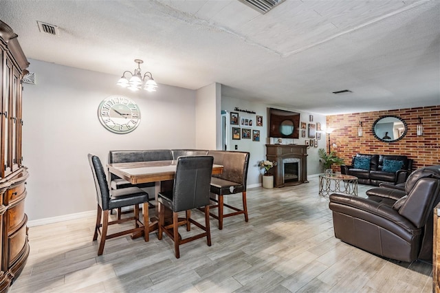 1403 Tallahassee Dr, Tarpon Springs, FL 34689 - dining room with a fireplace, light wood-style flooring, a chandelier, and a textured ceiling
