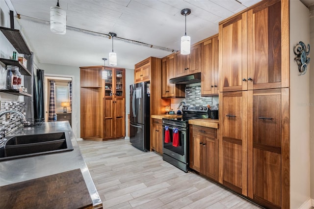 1403 Tallahassee Dr, Tarpon Springs, FL 34689 - kitchen featuring stainless steel electric range, freestanding refrigerator, under cabinet range hood, backsplash, and brown cabinetry