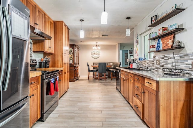 1403 Tallahassee Dr, Tarpon Springs, FL 34689 - kitchen with refrigerator, stainless steel range with electric stovetop, under cabinet range hood, light countertops, and brown cabinets
