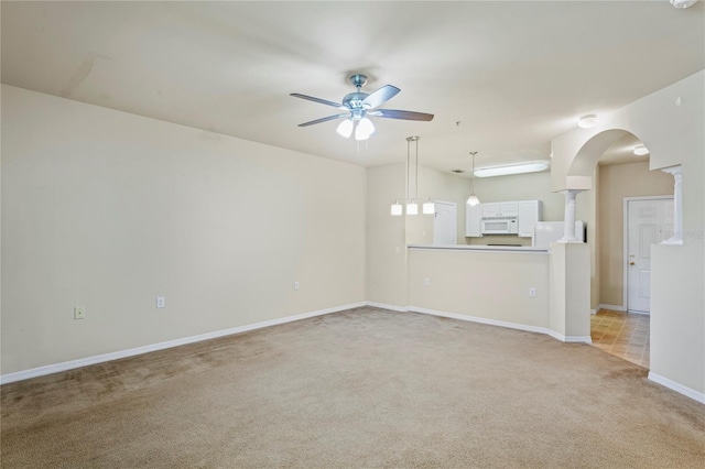 1640 Villa Capri Cir Unit 206, Odessa, FL 33556 - unfurnished living room with light colored carpet, ceiling fan, arched walkways, and ornate columns
