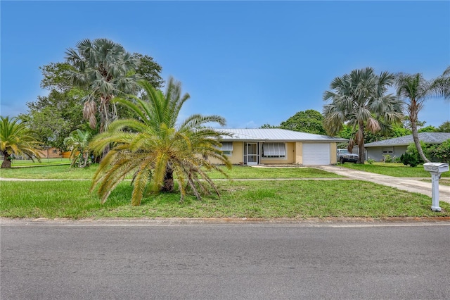 1340 NE Mariposa Dr NE, Palm Bay, FL 32905 - view of front of home featuring a garage, driveway, and a front yard