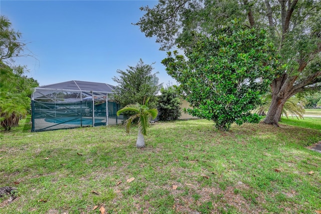 1340 NE Mariposa Dr NE, Palm Bay, FL 32905 - view of green lawn featuring an outdoor pool and glass enclosure