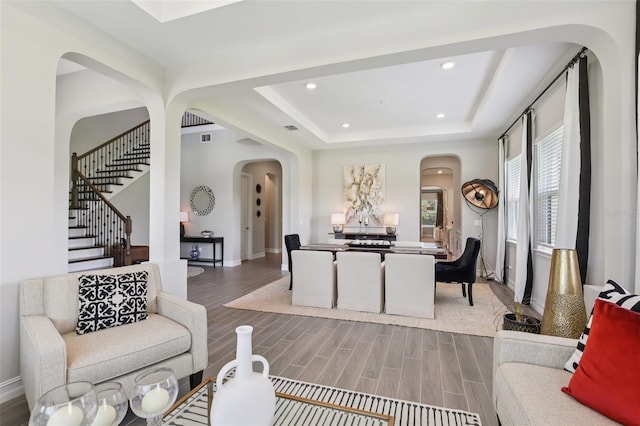 2903 Cordoba Ranch Blvd, Lutz, FL 33559 - living room featuring arched walkways, wood finished floors, a tray ceiling, recessed lighting, and stairway