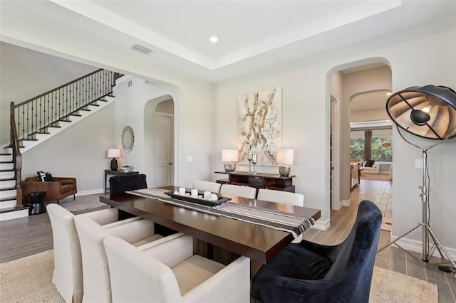 2903 Cordoba Ranch Blvd, Lutz, FL 33559 - dining space featuring arched walkways, stairs, wood finished floors, recessed lighting, and a raised ceiling