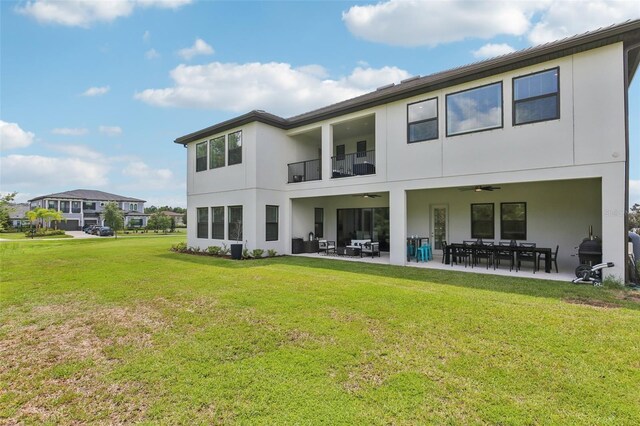2903 Cordoba Ranch Blvd, Lutz, FL 33559 - rear view of house featuring stucco siding, a ceiling fan, a balcony, a yard, and a patio