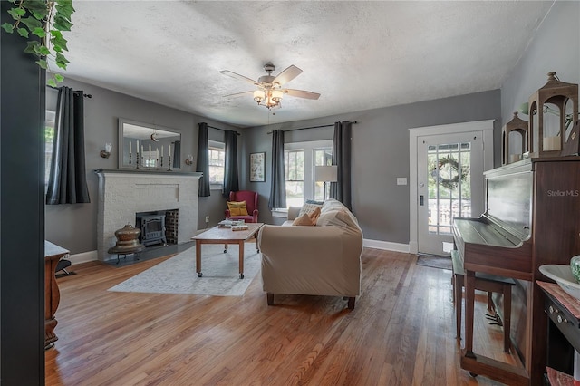 917 W Idlewild Ave, Tampa, FL 33604 - living area with wood finished floors, a textured ceiling, ceiling fan, and a brick fireplace