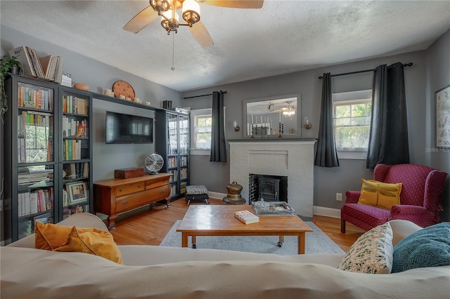 917 W Idlewild Ave, Tampa, FL 33604 - living area featuring ceiling fan, wood finished floors, a fireplace, and a textured ceiling