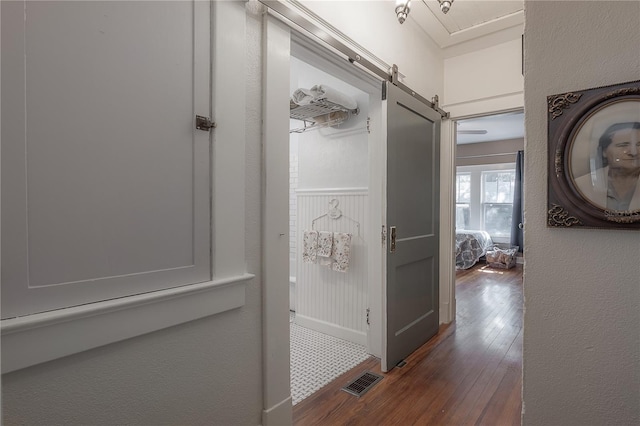 917 W Idlewild Ave, Tampa, FL 33604 - corridor with dark wood-style flooring, a barn door, and wainscoting