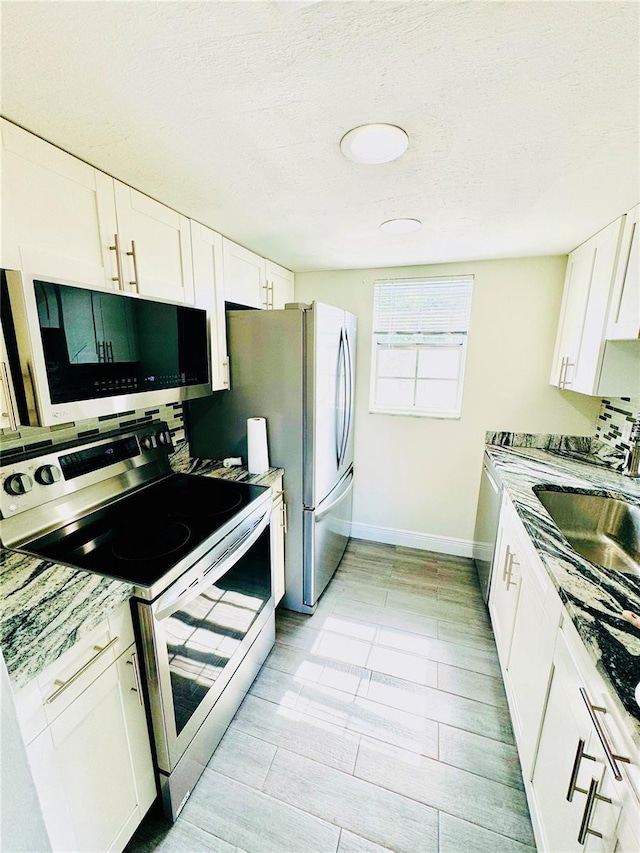4611 W N B St Unit 228, Tampa, FL 33609 - kitchen with stainless steel range with electric cooktop, white cabinets, light countertops, a textured ceiling, and light wood finished floors