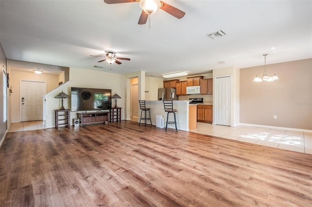15420 Quail Woods Pl, Ruskin, FL 33573 - living area featuring a ceiling fan, light wood-style floors, and a chandelier
