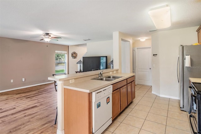 15420 Quail Woods Pl, Ruskin, FL 33573 - kitchen featuring appliances with stainless steel finishes, a ceiling fan, light countertops, a breakfast bar area, and brown cabinets