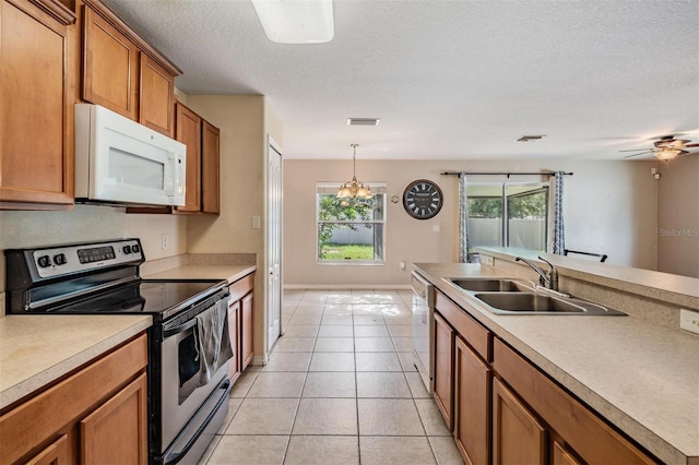 15420 Quail Woods Pl, Ruskin, FL 33573 - kitchen with white appliances, brown cabinets, light countertops, light tile patterned floors, and hanging light fixtures