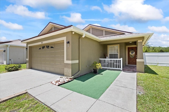 9831 Edmonton Dr, Land O Lakes, FL 34638 - view of front of home with a garage, stucco siding, covered porch, driveway, and a front lawn