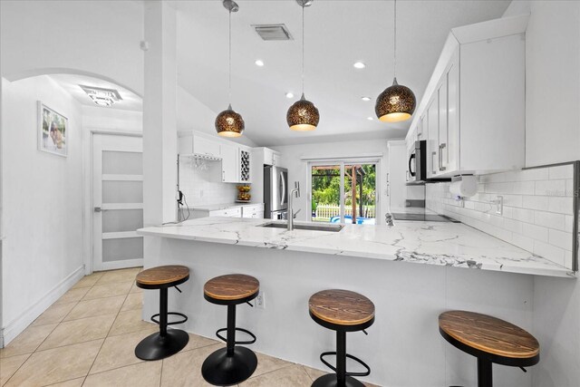 9831 Edmonton Dr, Land O Lakes, FL 34638 - kitchen with stainless steel appliances, a peninsula, decorative backsplash, white cabinets, and recessed lighting