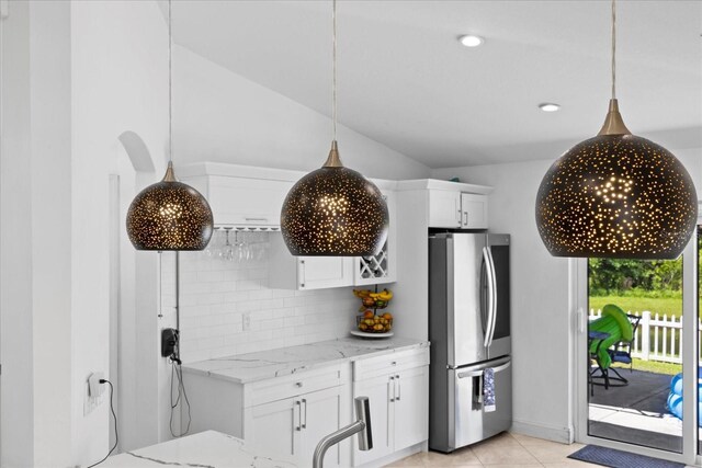 9831 Edmonton Dr, Land O Lakes, FL 34638 - kitchen featuring freestanding refrigerator, light stone counters, backsplash, white cabinetry, and light tile patterned floors