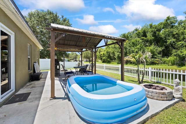 9831 Edmonton Dr, Land O Lakes, FL 34638 - view of pool with an outdoor fire pit, a fenced backyard, a gazebo, a patio area, and view of wooded area