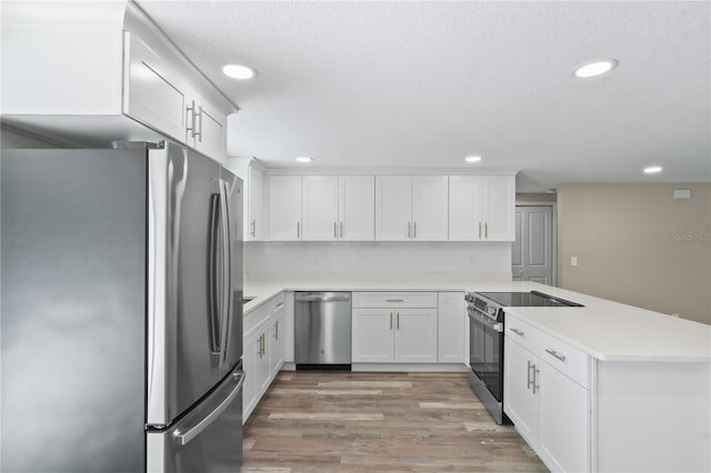 561 Golf And Sea Blvd, Apollo Beach, FL 33572 - kitchen featuring appliances with stainless steel finishes, a peninsula, light countertops, recessed lighting, and white cabinets