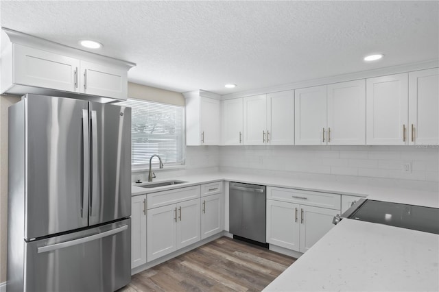 561 Golf And Sea Blvd, Apollo Beach, FL 33572 - kitchen with stainless steel appliances, a textured ceiling, white cabinetry, wood finished floors, and light countertops