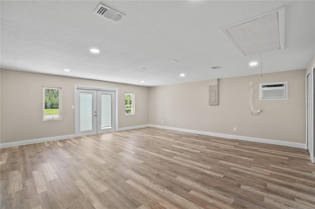 561 Golf And Sea Blvd, Apollo Beach, FL 33572 - unfurnished room with attic access, an AC wall unit, light wood-style floors, recessed lighting, and electric panel