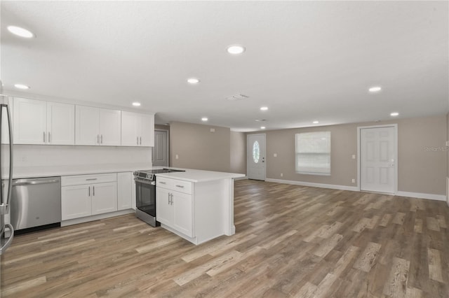 561 Golf And Sea Blvd, Apollo Beach, FL 33572 - kitchen featuring appliances with stainless steel finishes, a peninsula, recessed lighting, and light wood-style flooring