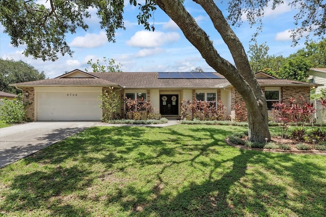 6706 Dunes Ln, Temple Terrace, FL 33617 - single story home featuring an attached garage, a front yard, roof mounted solar panels, and concrete driveway
