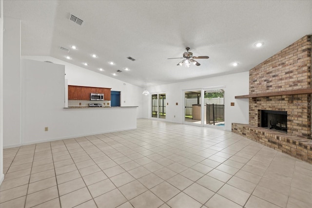 6706 Dunes Ln, Temple Terrace, FL 33617 - unfurnished living room featuring vaulted ceiling, a ceiling fan, a brick fireplace, light tile patterned flooring, and a textured ceiling