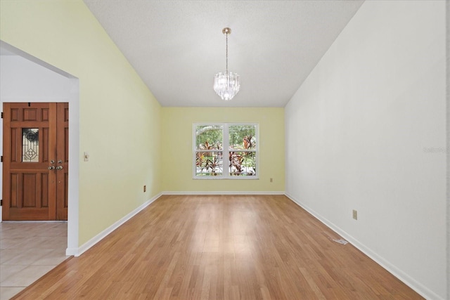6706 Dunes Ln, Temple Terrace, FL 33617 - empty room featuring vaulted ceiling, a chandelier, and light wood-style flooring