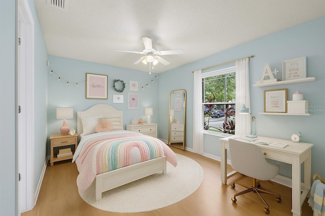 6706 Dunes Ln, Temple Terrace, FL 33617 - bedroom with an office area, wood finished floors, and a ceiling fan