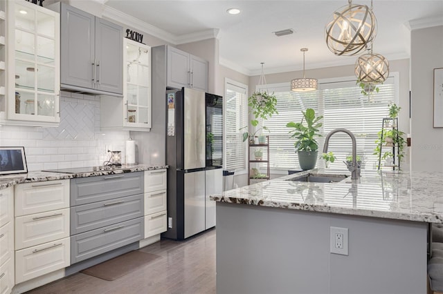4147 Grandchamp Cir, Palm Harbor, FL 34685 - kitchen with smart refrigerator, black electric stovetop, crown molding, tasteful backsplash, and glass insert cabinets