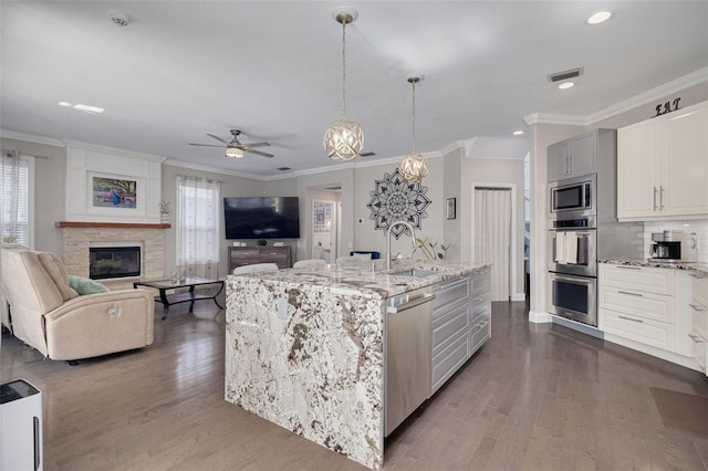 4147 Grandchamp Cir, Palm Harbor, FL 34685 - kitchen with appliances with stainless steel finishes, plenty of natural light, ornamental molding, ceiling fan, and dark wood finished floors