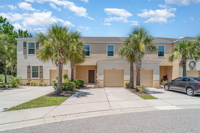 12841 Buffalo Run Dr, Gibsonton, FL 33534 - townhome / multi-family property featuring driveway, stucco siding, and an attached garage