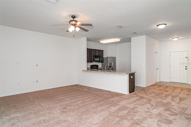 12841 Buffalo Run Dr, Gibsonton, FL 33534 - kitchen with black microwave, stainless steel fridge, light carpet, ceiling fan, and a peninsula
