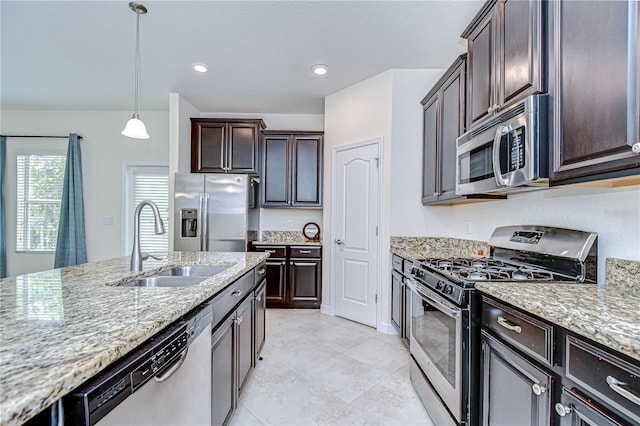 828 Terra Vista St, Brandon, FL 33511 - kitchen with stainless steel appliances, dark brown cabinets, light stone counters, pendant lighting, and recessed lighting