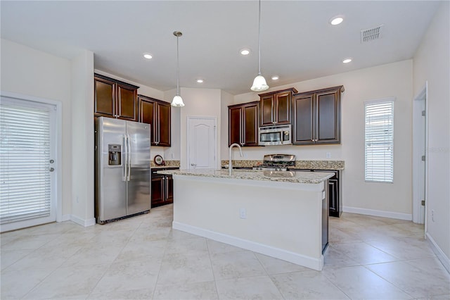 828 Terra Vista St, Brandon, FL 33511 - kitchen with appliances with stainless steel finishes, recessed lighting, dark brown cabinets, hanging light fixtures, and a kitchen island with sink