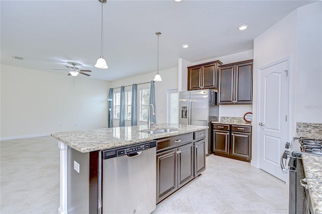 828 Terra Vista St, Brandon, FL 33511 - kitchen featuring stainless steel appliances, ceiling fan, dark brown cabinets, hanging light fixtures, and an island with sink