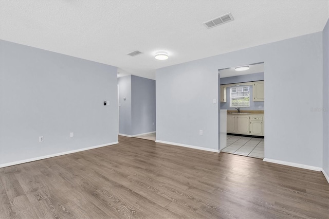 1706 Belleair Forest Dr Unit 146, Belleair, FL 33756 - unfurnished room with light wood-style floors and a textured ceiling