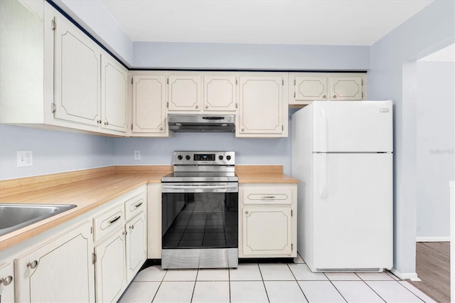 1706 Belleair Forest Dr Unit 146, Belleair, FL 33756 - kitchen featuring freestanding refrigerator, electric stove, extractor fan, light countertops, and light tile patterned flooring