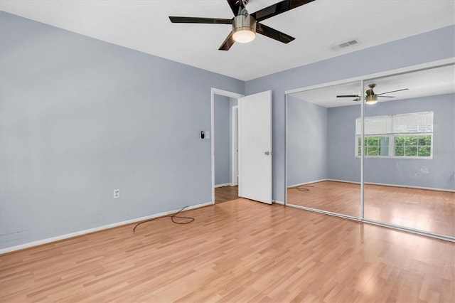 1706 Belleair Forest Dr Unit 146, Belleair, FL 33756 - unfurnished bedroom with wood finished floors, a ceiling fan, and a closet