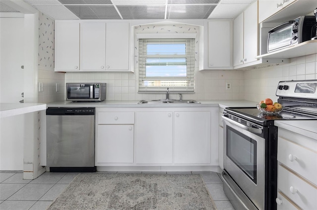 4775 Cove Cir Unit 803, Saint Petersburg, FL 33708 - kitchen featuring stainless steel appliances, light tile patterned floors, decorative backsplash, and light countertops